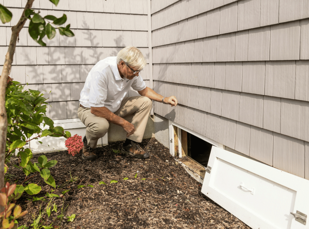 man examining wall and vent conditions during home inspection