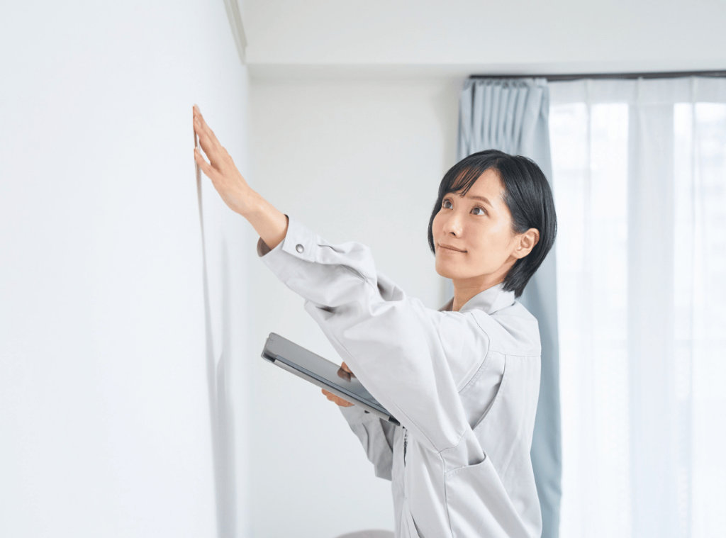 woman assessing walls and interior during home inspection