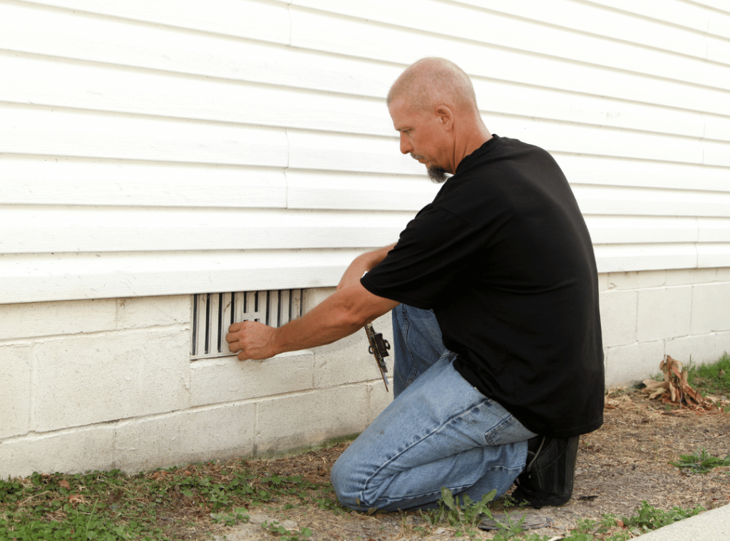 man inspecting vents and exterior conditions during home inspection
